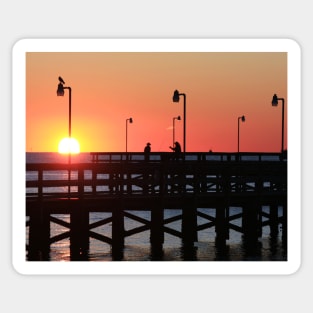 Two fishermen sillouhetted on the pier at sunrise Sticker